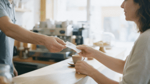 Camarero entregando un ticket con código QR Verifactu en la barra de una cafetería